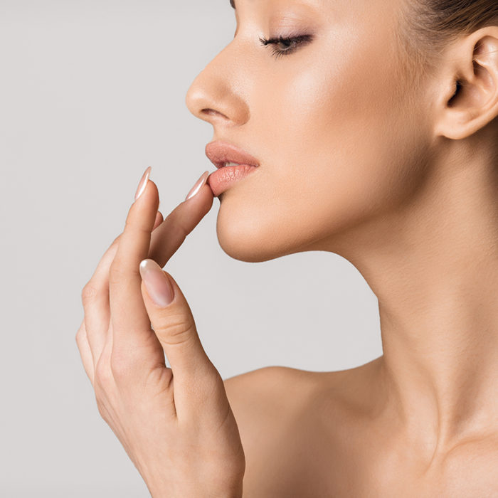 model touching her lips over gray background