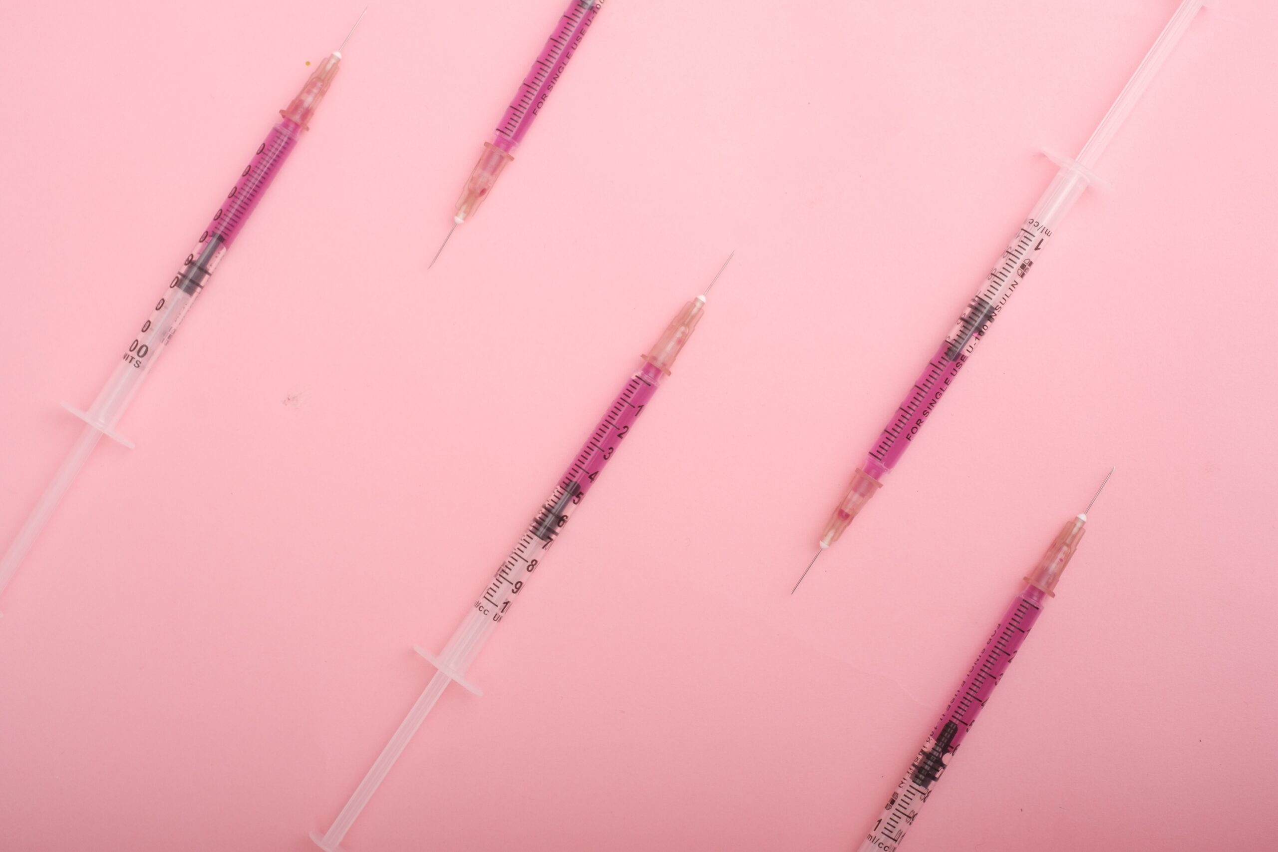 syringes on pink background